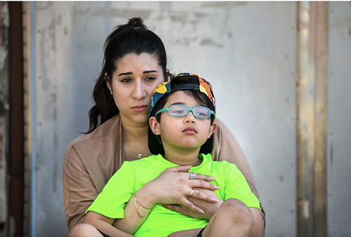 JESSICA GRIFFIN / STAFF Cristine Pagan, with her son Dean, who was poisoned by flaking lead paint at Comly Elementary School.